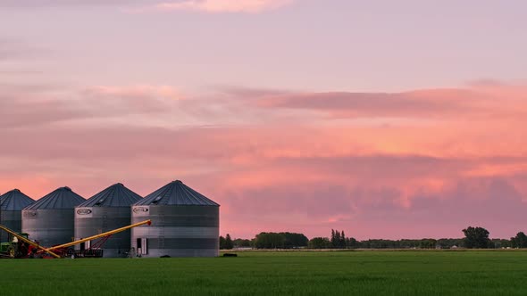 Colorful sunset over farm fields in Idaho looking past grain bins