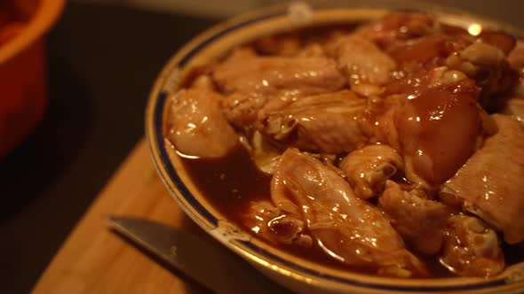 Chicken wings in red spicy sauce, carrots, green salad, leek, red pepper. Camera panning right to le