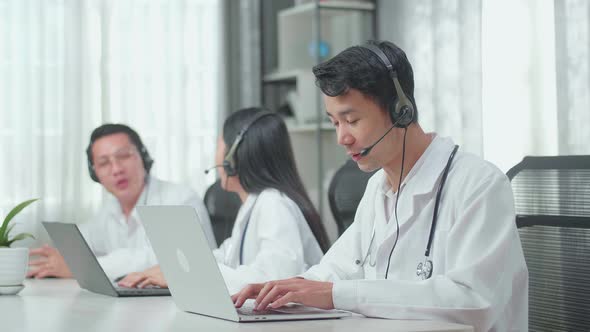 Man Of Three Doctors Working As Call Centre Agents Speaking To Customers While Colleagues Talking