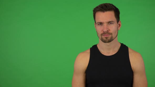 A Young Handsome Athlete Looks Seriously at the Camera - Green Screen Studio