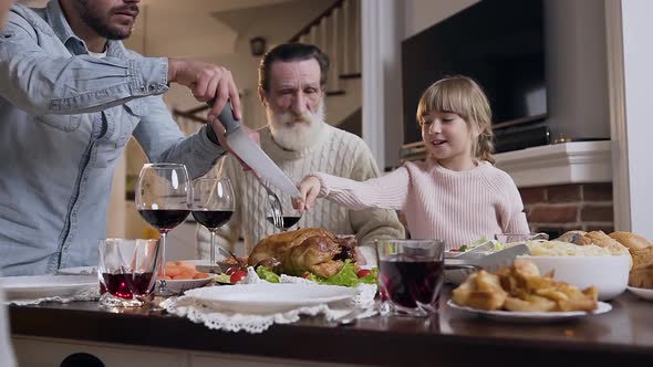 Pretty Girl Showing Her Father what Part of Roast Turkey She Wants to Eat