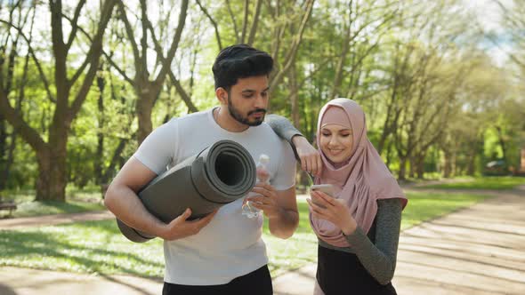 Handsome Arabian Guy with Yoga Mat and Bottle of Water Looking at His Charming