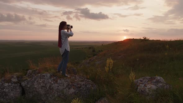 Girl Stands on the Big Rock and Starts Shooting on Her Camera