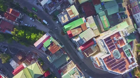 Drone Shows Street with Coloured Rooftops and Slow Traffic