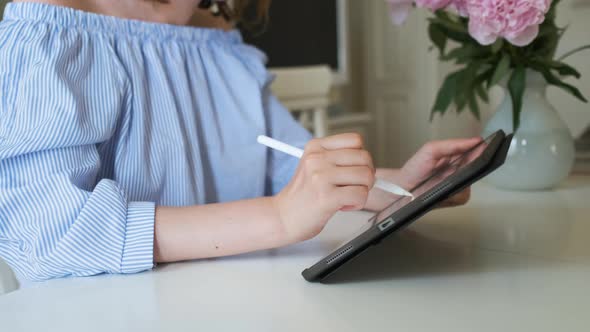 Woman Working on the Tablet Using Pencil in the Light Modern Interior