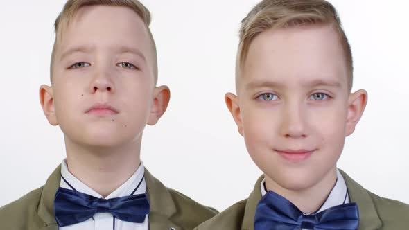 Blond Blue-Eyed Identical Twins Posing Together on White