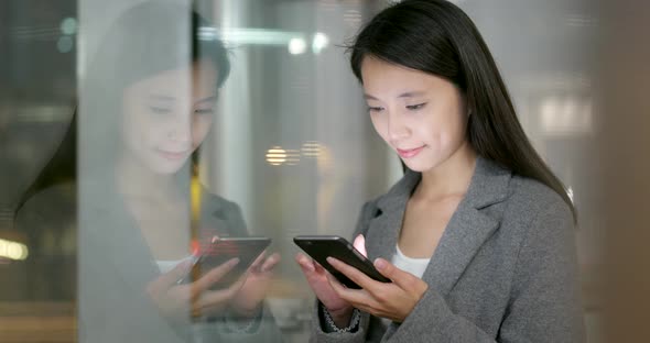 Business Woman Look at Smart Phone with Window Reflection at Night