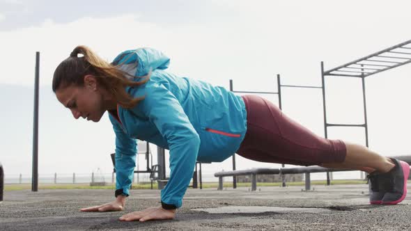 Sporty Caucasian woman exercising in an outdoor gym during daytime