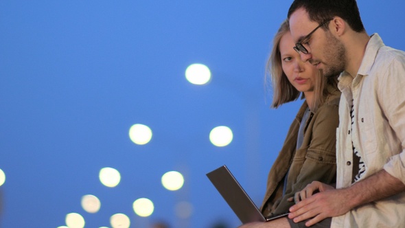 Man meets a woman on a bench and brings laptop with him