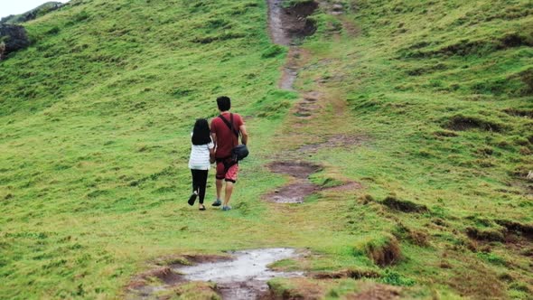 Father and daughter walking up a hill in Batanes, Philippines - PAN UP