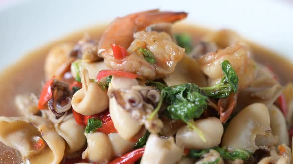 Squid and shrimp fried basil on a white plate