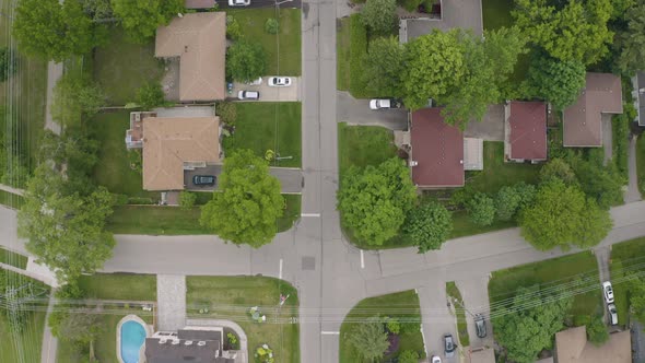 Suburban neighborhood. Top-down view from drone. Travels down street with backyards and properties v