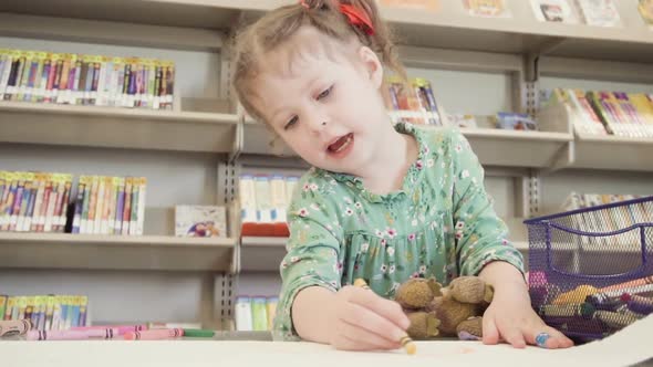 Slow motion. Little girl drawing at the local library.