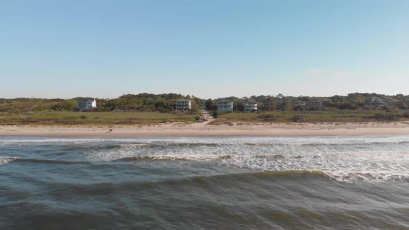 4k drone shot of beach in Oak Island NC on a bright sunny day