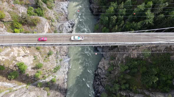 4k cinematic aerial footage of high canyon bridge in northern Canada on a sunny day. Cars crossing b