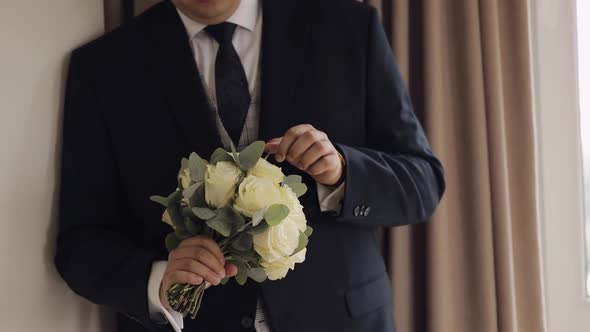 Groom with Wedding Bouquet in His Hands at Home Preparing to Go to Bride Closeup Slow Motion