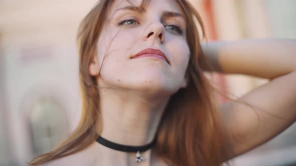 Beautiful Young Redhaired Woman Motorcyclist Removes Helmet on Sunset