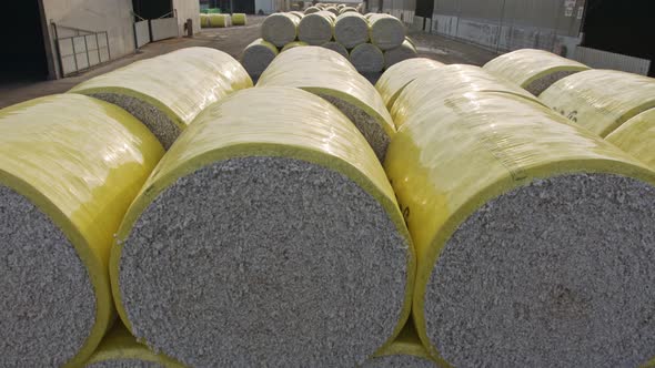 Large stacks of cotton bales at a cotton gin after harvest