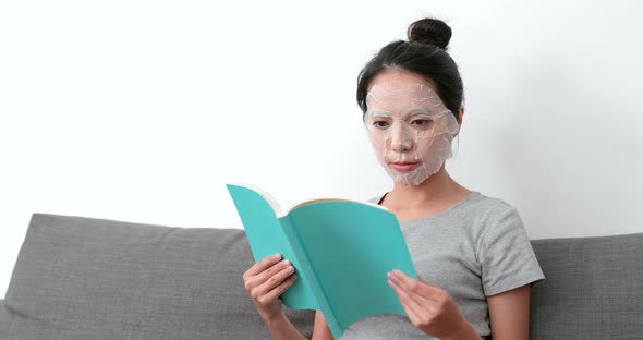 Woman apply paper mask and read book