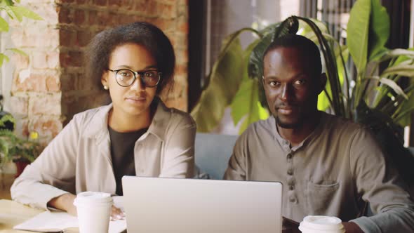 Afro-American Coworkers Posing for Camera on Coffee Break in Cafe