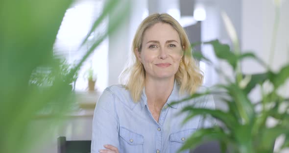 Smiling businesswoman looking at camera with arms crossed