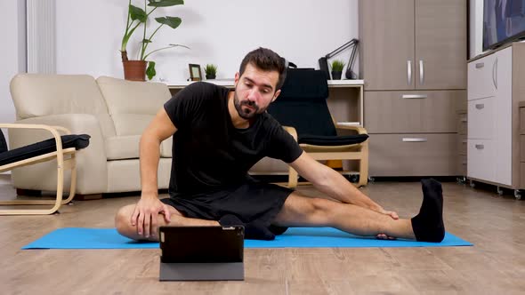 Man Repeating Exercises After What He Sees on a Digital Tablet PC