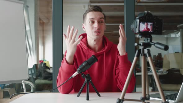 Young Blogger Man Filming New Vlog Video with Professional Camera at Workplace at Office