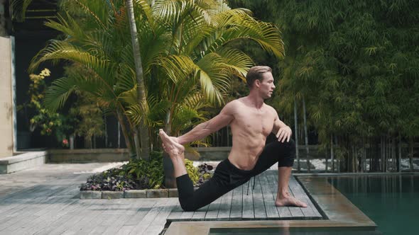 Fitness Caucasian Sporty Man Doing Yoga and Stretching Muscles