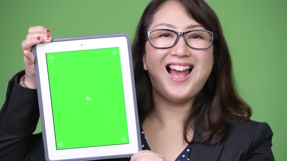 Mature Beautiful Asian Businesswoman Showing Digital Tablet