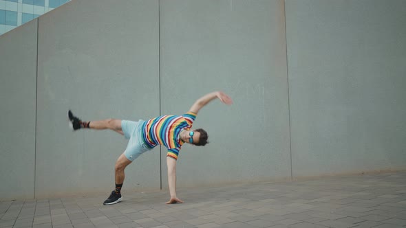 Flexible and cool businessman doing acrobatic tricks outdoor.