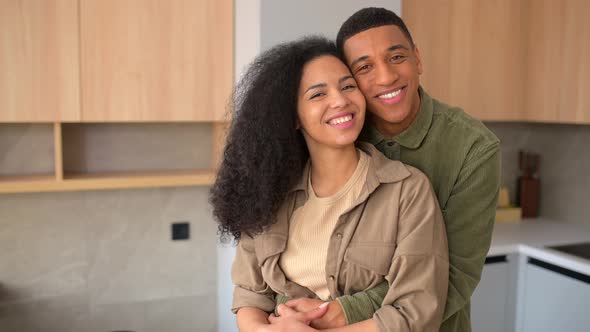Sweet Multiethnic Couple in Love Standing in Embraces in the Kitchen