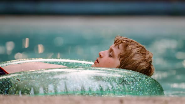 Boy Laying on an Inflatable Circle and Floating in the Pool on Summer Vacation