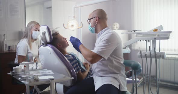 Dentist Checking Healthy Teeth of Teen Boy
