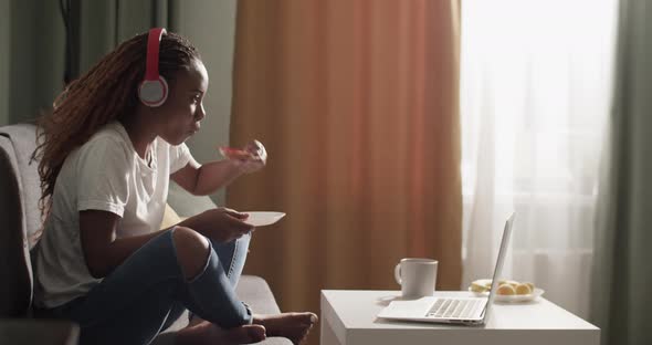 African American Female Eating Toast and Watching Movie