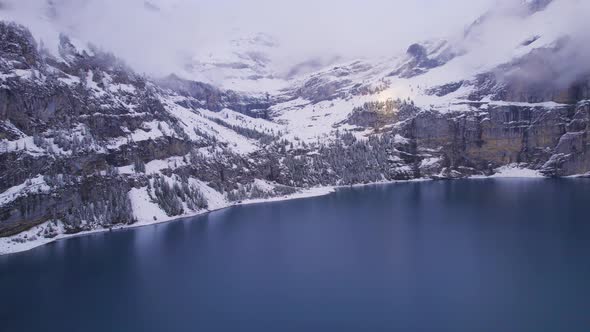 Oeschinen Lake in Switzerland Surrounded by Snow Covered Forests and Mountains