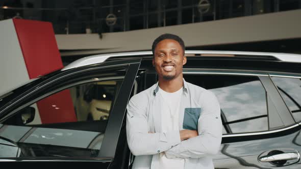 African American Car Dealership Principal Standing in Vehicle Showroom