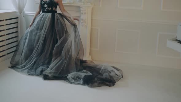 Girl in beautiful dress. Young woman in evening dress posing in decorated room in studio