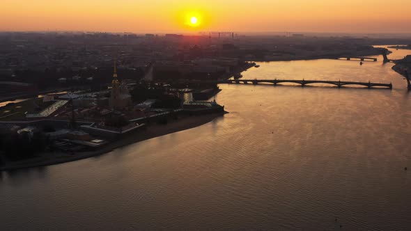 Drone Flight Over the Neva River to the Peter and Paul Fortress at Sunrise Reflection of the Orange