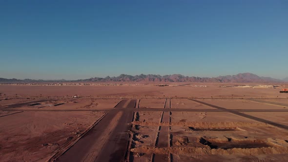 Flight over the desert in Egypt. Cars are driving far away