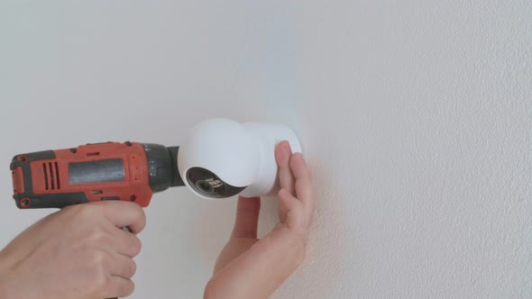 Man Hands Use Electric Drill And Install Cctv Camera On Wall For Security