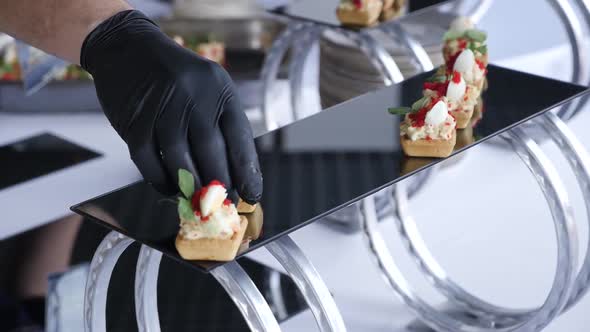 The Waiter Puts the Food on a Beautiful Table During the Buffet Table