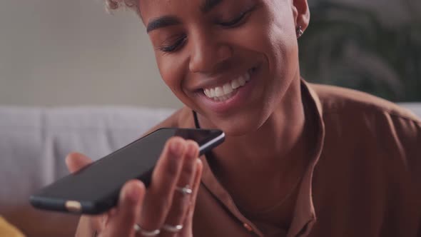 Smiling African Lady Hold Use Modern Smartphone Gadget Talk Speak on Loudspeaker