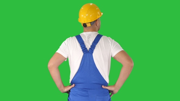 Engineer in construction helmet standing with hands on