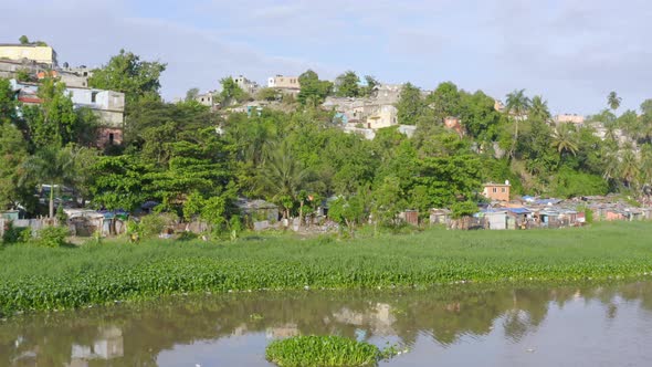 Shacks along Ozama river shores at Santo Domingo. Aerial forward