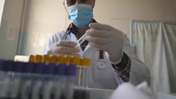 Doctor Wearing Medical Uniform Checking and Viewing Test Tubes