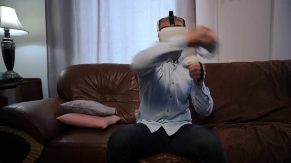 Frotn View Absorbed Man in VR Headset Imitating Boxing Gaming Online in Living Room at Home