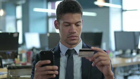 Portrait of African Businessman Using Credit Card on Smartphone