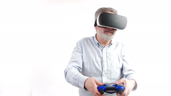 Mature Greyhaired Man Plays Video Games with Vr Goggles and Console Studio Shot Medium Shot White