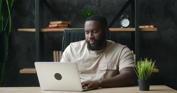 African Man Freelancer Working at Laptop at Modern Workplace Remotely at Home