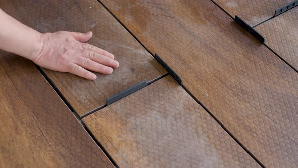 Carpenter Sets Spacing of Deck Boards on Floor Wood Panel